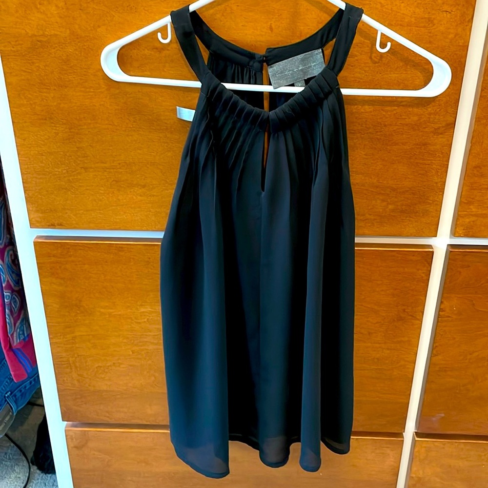 Dressy black top. High neck, key hole front, button and loop closure on back. XS